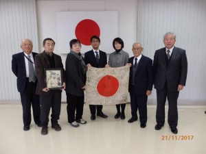 日章旗を受け取る甥の孝一さんら遺族