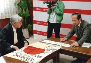 日章旗を神谷学・安城市長から受け取った本田紘さん（左）