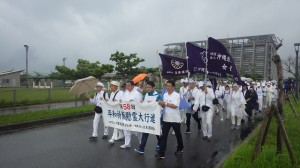 雨が降りしきる中、恒久平和を願い摩文仁の丘を目指す行進団