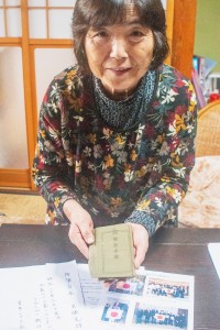 軍事手帳を受け取った富塚昭子さん＝山形県